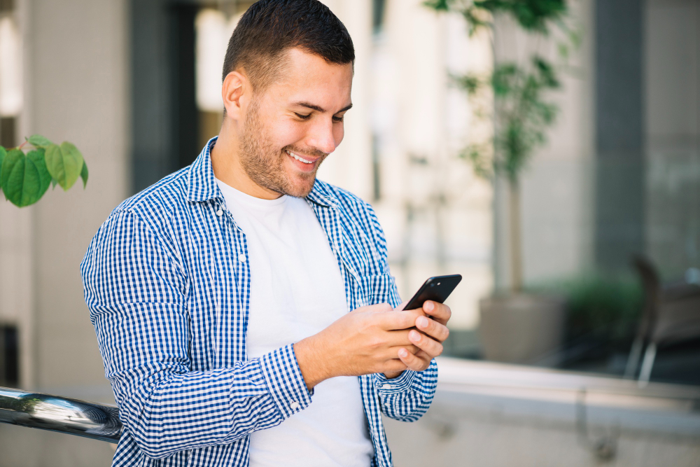 Hombre usando teléfono inteligente - planes Telcel Recall
